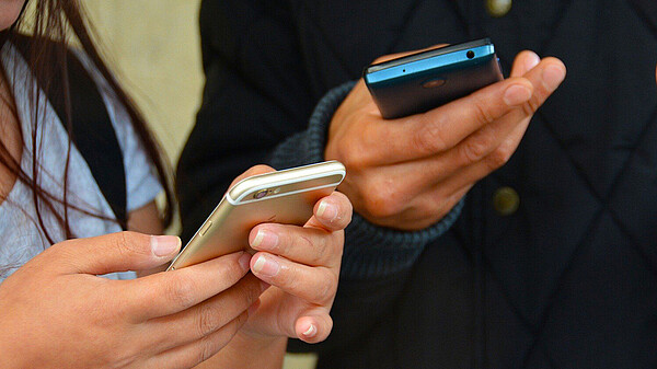 Zwei Personen mit Handys in der Hand