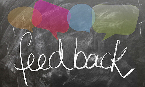 Schriftzug Feedback mit Sprechblasen drüber