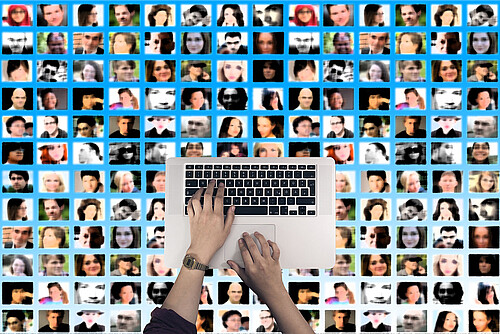 Laptop, im Hintergrund Kacheln mit Gesichtern